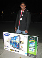 Dipak poses with a large LCD television box